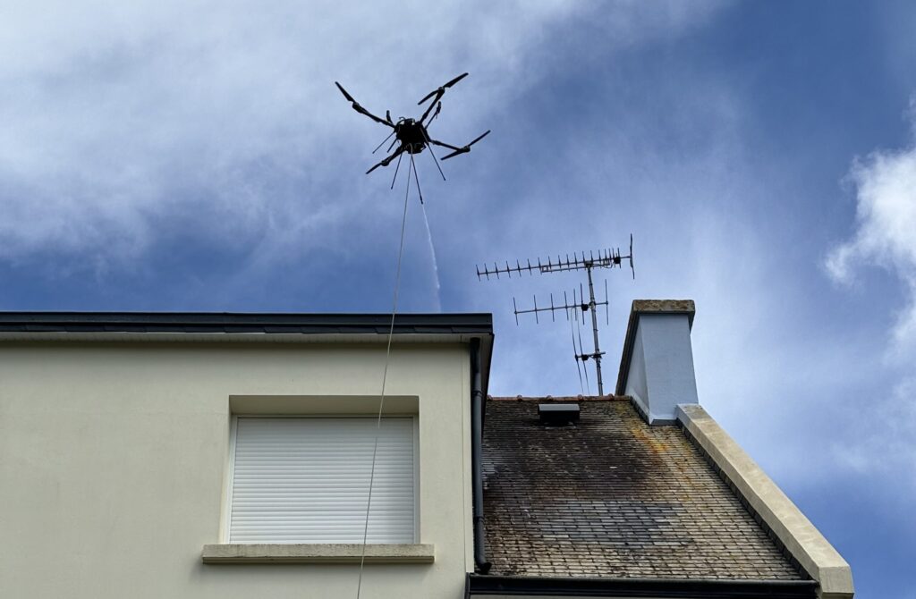 Démoussage de toiture réalisé au drone sur un immeuble.